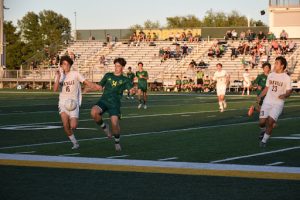 Sophomore Malik Mujezinovic (34) battles for a ball bouncing towards the sideline, “I just keep pushing to get a goal, and when we get a goal it builds up the confidence to keep aiming for more goals,” said Mujezinovic (34). The Flyers settled for a tie after 90. 